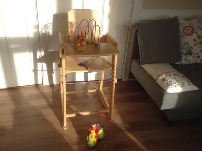 a wooden chair with a toy on it next to a couch at Familie Quellhorst in Leiden