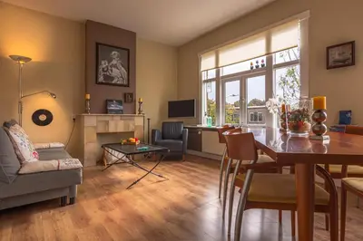 a living room with a table and a dining room at Familie Quellhorst in Leiden