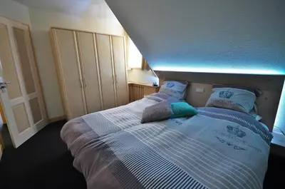 a bedroom with a bed with blue lights on it at Westenwind in Egmond aan Zee