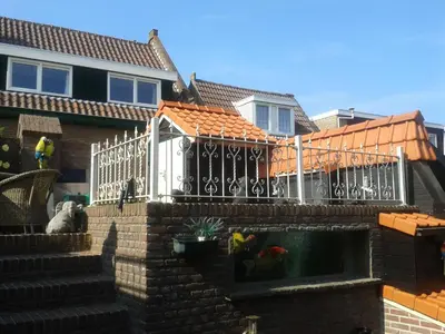 a house with a fence and a swimming pool at Westenwind in Egmond aan Zee