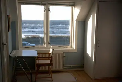 a room with a desk and a window with the ocean at Zeeduin - fantastisch uitzicht op zee in Bergen aan Zee