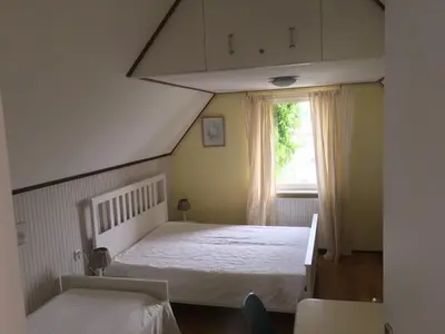 a bedroom with a white bed and a window at Zeeduin - fantastisch uitzicht op zee in Bergen aan Zee