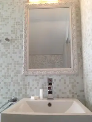 a bathroom with a tub with a mirror and a sink at Zeeduin - fantastisch uitzicht op zee in Bergen aan Zee