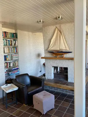a living room with a couch and a fireplace at Pacific, spectacular seaview in Bergen aan Zee