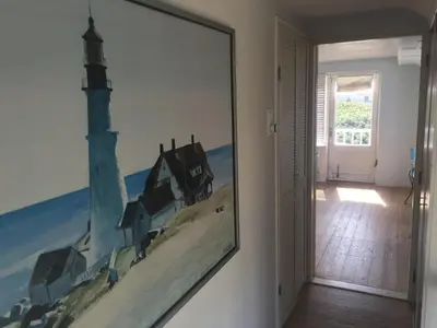 a painting of a lighthouse on a wall in a room at Pacific, spectacular seaview in Bergen aan Zee