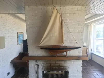 a wooden sail boat hanging on a brick wall at Pacific, spectacular seaview in Bergen aan Zee