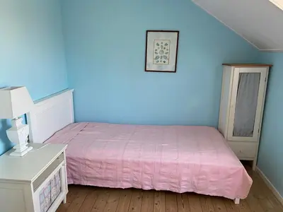 a bedroom with a pink bed and blue walls at Pacific, spectacular seaview in Bergen aan Zee
