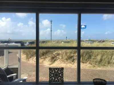 a view of a beach from a window at Pacific, spectacular seaview in Bergen aan Zee