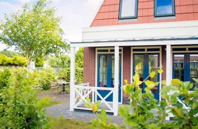 a red brick house with a blue and white door at Bungalow 6p in Noordwijk