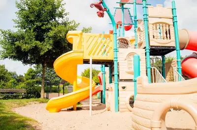 a playground with a slide in a park at Bungalow 6p in Noordwijk