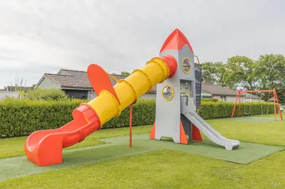 a playground with a slide and a rocket launcher at Vakantiepark Zijpersluis in Burgerbrug