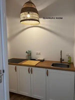 a kitchen with a sink and a pendant light at El Sol Zandvoort in Zandvoort