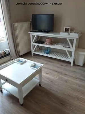 a living room with a tv and a white coffee table at El Sol Zandvoort in Zandvoort