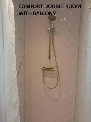 a shower with a hose in a bathroom at El Sol Zandvoort in Zandvoort
