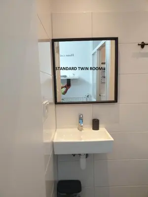 a bathroom with a sink and a mirror at El Sol Zandvoort in Zandvoort