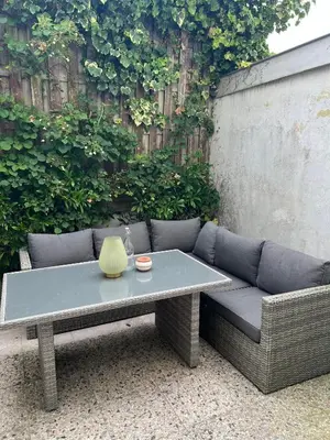 a couch with a table in front of a fence at El Sol Zandvoort in Zandvoort