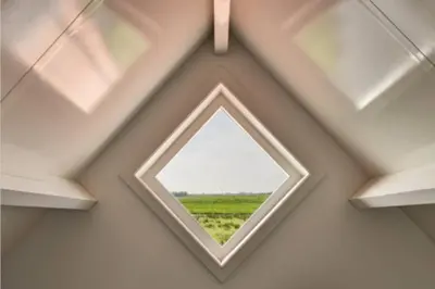 a window in the ceiling of a room with a field at Romantic Dutch hideaway in Jisp