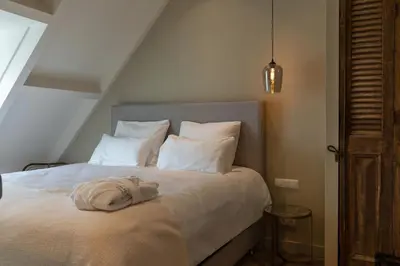 a bedroom with a bed with white sheets and pillows at Parkhotel Abcoude in Abcoude