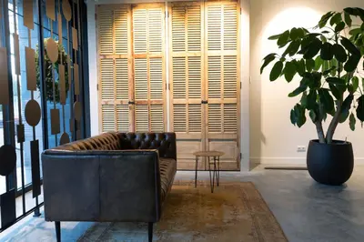 a leather couch in a room with a potted plant at Parkhotel Abcoude in Abcoude