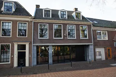 a brick building with windows on a street at Parkhotel Abcoude in Abcoude