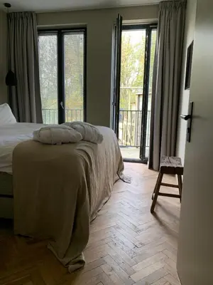 a bedroom with a bed and a large window at Parkhotel Abcoude in Abcoude