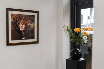 a picture of a woman with a vase of flowers at King's Inn City Hotel Alkmaar in Alkmaar