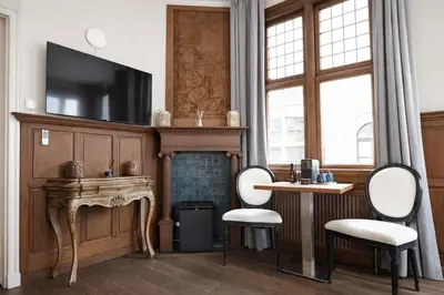 a living room with a fireplace and a tv on a wall at King's Inn City Hotel Alkmaar in Alkmaar