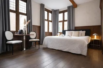 a bedroom with a bed and a table and chairs at King's Inn City Hotel Alkmaar in Alkmaar