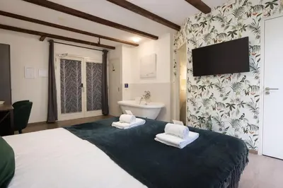 a bedroom with a large bed with towels on it at King's Inn City Hotel Alkmaar in Alkmaar
