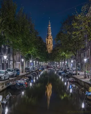 a view of a canal with a clock tower at night at Leidse Square 5 star Luxury Apartment in Amsterdam