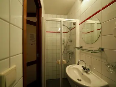 a bathroom with a sink and a shower and a mirror at Hotelboat Sarah in Amsterdam