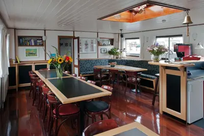 a restaurant with tables and chairs and a counter at Hotelboat Sarah in Amsterdam