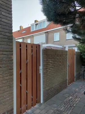 a wooden fence in front of a house at Zomerhuis Simoons in Egmond aan Zee