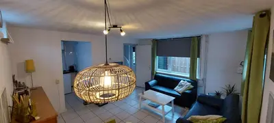 a living room with a bird cage hanging from the ceiling at Zomerhuis Simoons in Egmond aan Zee