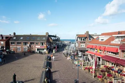 a street in a town with tables and chairs at Zomerhuis Simoons in Egmond aan Zee