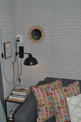 a room with a couch and a lamp and a mirror at Studio Clematis Bergen in Bergen