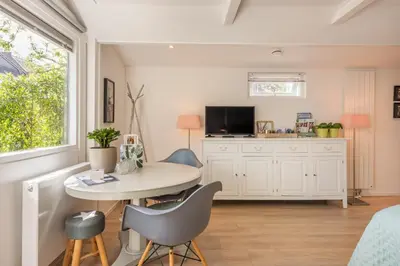 a kitchen with a table and chairs in a room at Studio Clematis Bergen in Bergen