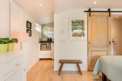 a bedroom with a bed and a table and a door at Studio Clematis Bergen in Bergen