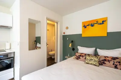 a bedroom with a white bed and a bathroom at Amsterdam Dockside Flats in Amsterdam
