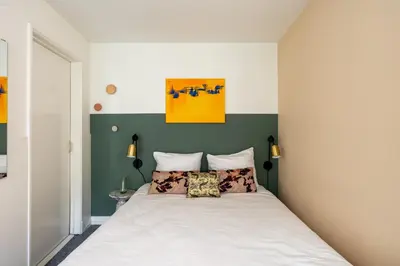a bedroom with a bed with a green accent wall at Amsterdam Dockside Flats in Amsterdam