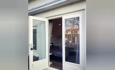 an open door to a room with a bed at Queens Beachhouse in Zandvoort