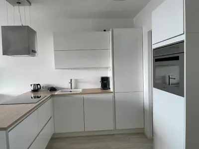 a white kitchen with white cabinets and a sink at Happy Beach Apartment in Zandvoort