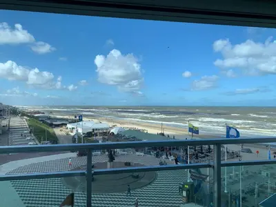 a view of the beach from a balcony of a building at Happy Beach Apartment in Zandvoort