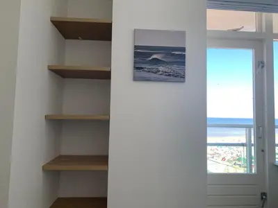a room with shelves and a door with a window at Happy Beach Apartment in Zandvoort