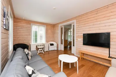 a living room with a couch and a flat screen tv at The Black House - Luxurious Holiday Villa Zeewolde in Zeewolde