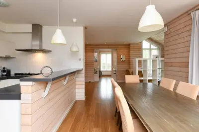 a kitchen and dining room with a wooden table at The Black House - Luxurious Holiday Villa Zeewolde in Zeewolde
