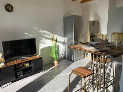 a living room with a television and a table with chairs at Queens Romantic Beachhouse in Zandvoort