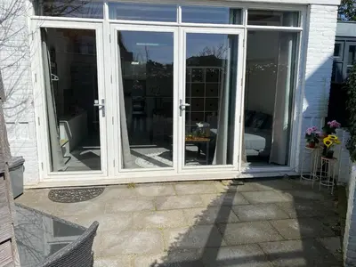 an open sliding glass door on a house at Queens Romantic Beachhouse in Zandvoort