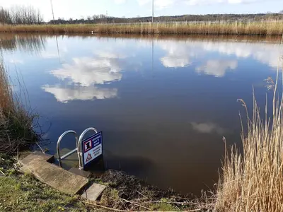 a sign in the middle of a body of water at Klein Heemshof - Noord Holland aan uw voeten in Warmenhuizen