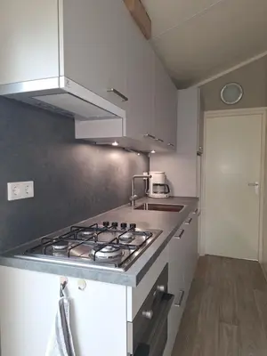 a kitchen with a stove top oven in a kitchen at Klein Heemshof - Noord Holland aan uw voeten in Warmenhuizen